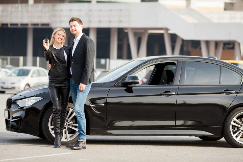 szczęśliwa młoda para wybiera i kupuje nowy samochód dla rodziny